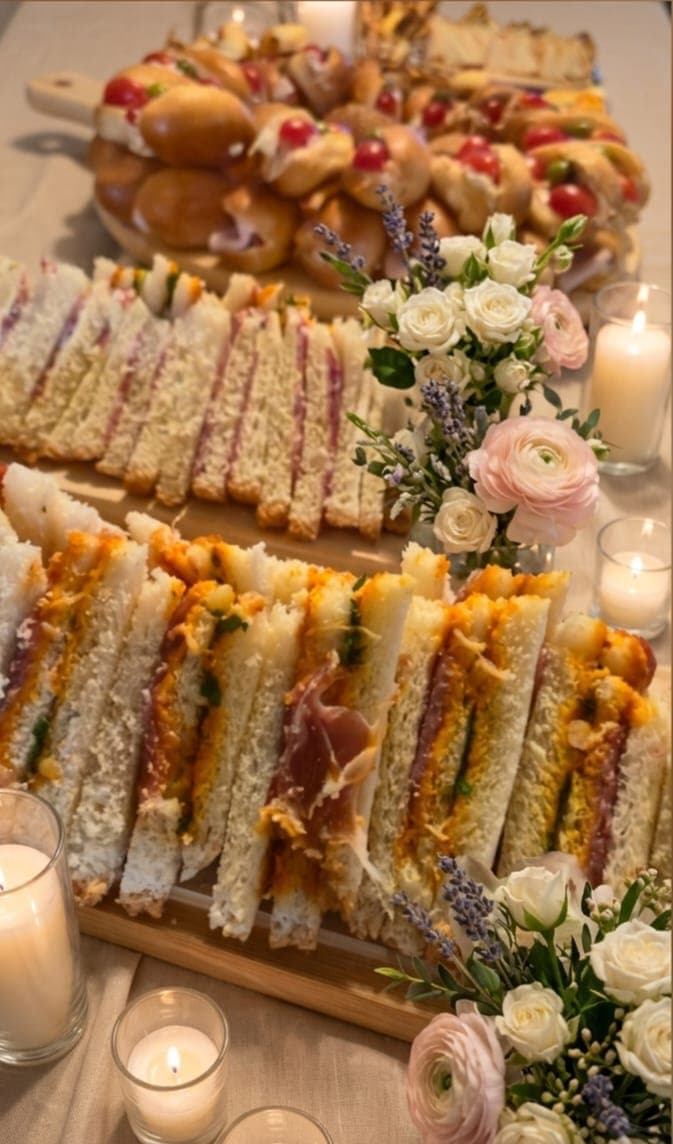 Planche de club-sandwichs coupés en triangles, bordée de fleurs et de bougies