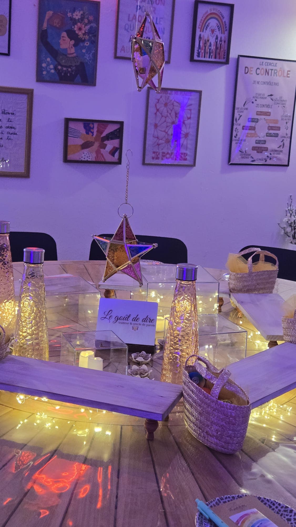 Étoile décorative suspendue au-dessus de la table, devant un mur de cadres illustrés
